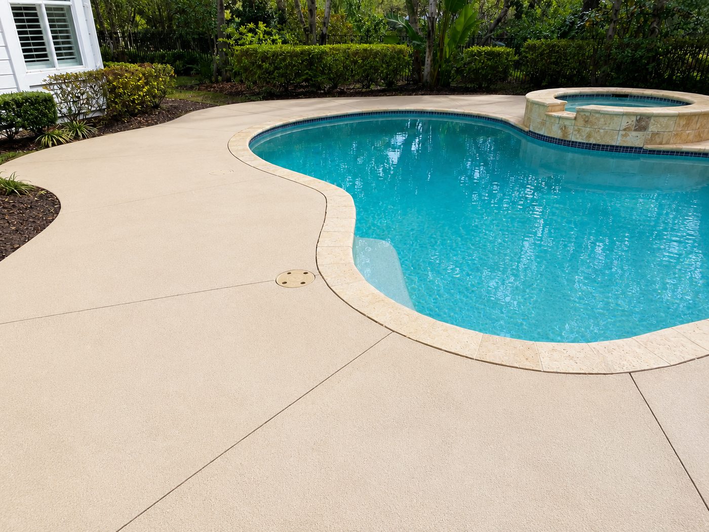 The same pool surround after cleaning, showing the restored pale concrete finish